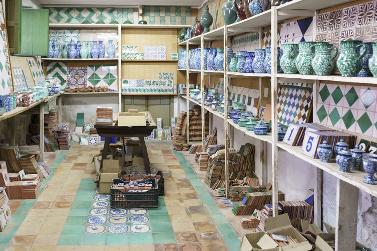 Various ceramic pieces arranged on rack in workshop