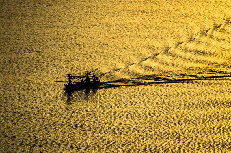 High angle view of silhouette ship on land against sky during sunset
