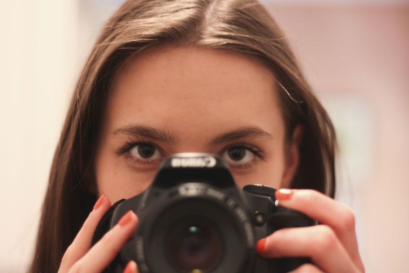 Close-up of woman holding camera