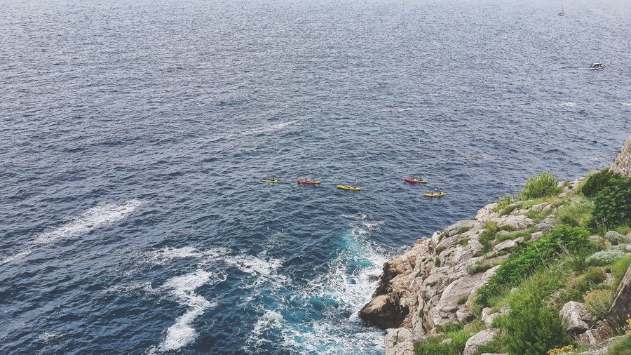 High angle view of people on rocks by sea