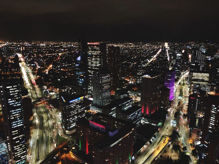 High angle view of illuminated cityscape against sky at night