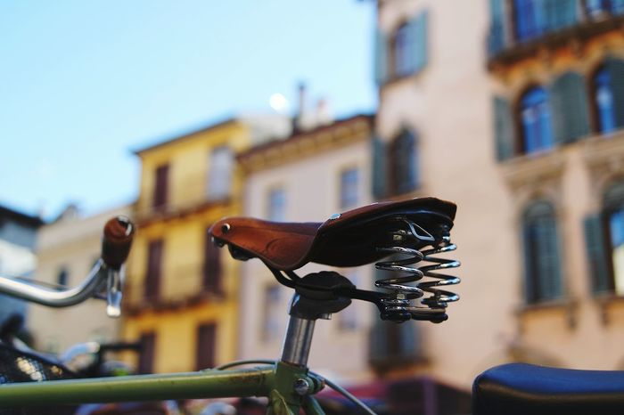 Close-up of cropped bicycle against buildings