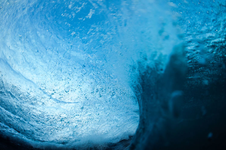Blue wave breaking on the beach in summer