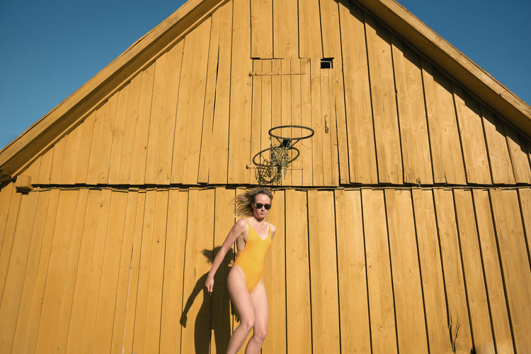 Low angle view of woman in bikini standing outdoors