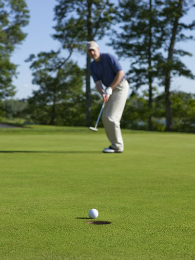 Blurred view of golfer on course shooting a hole in one