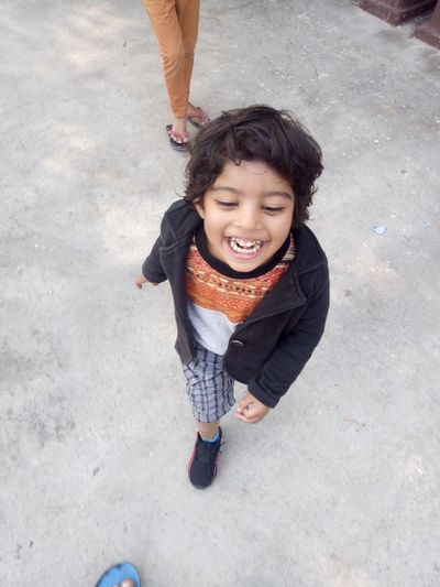 High angle view of smiling boy on street in city