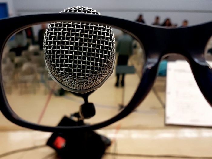 Close-up of microphone seen through eyeglasses