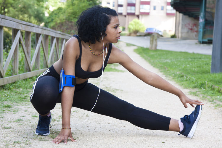 Young woman exercising on field