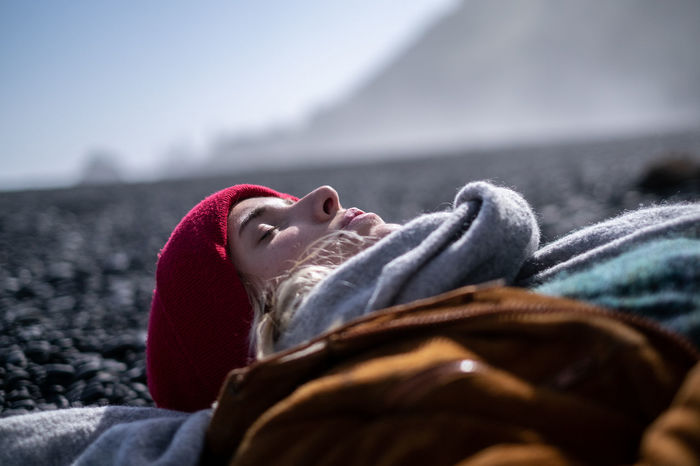 Young woman lying on stones during winter