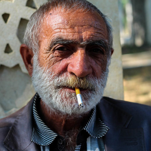 Close-up portrait of mature man smoking cigarette