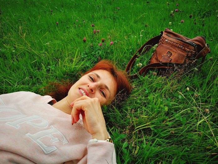 Portrait of smiling young woman lying on grass