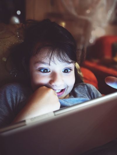 Cute surprised girl using digital tablet at home