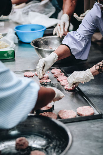 Cropped hands of women preparing food in kitchen