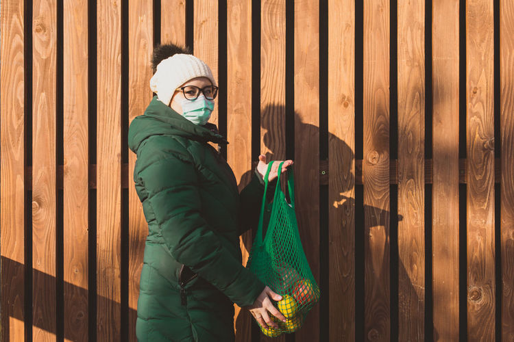 Woman with mesa bag against wooden wall