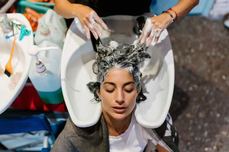 Woman in the hairdresser's shop shampooing her hair