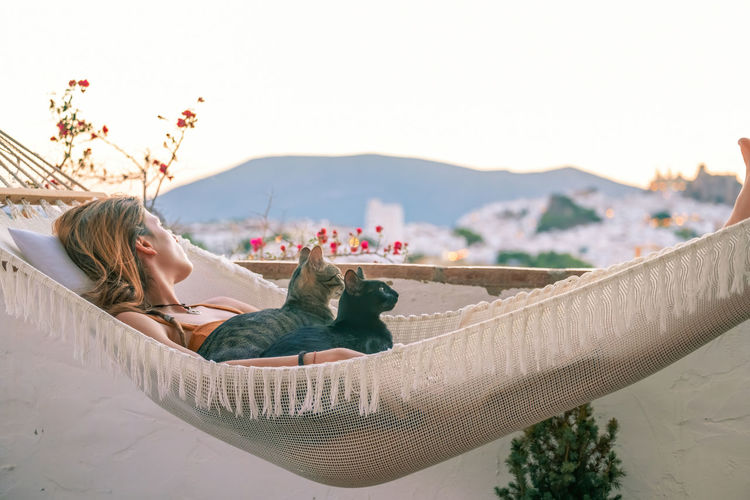 Woman relaxing against sky