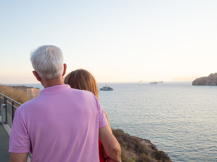 Elderly couple looking at the sea from a harbor lookout point