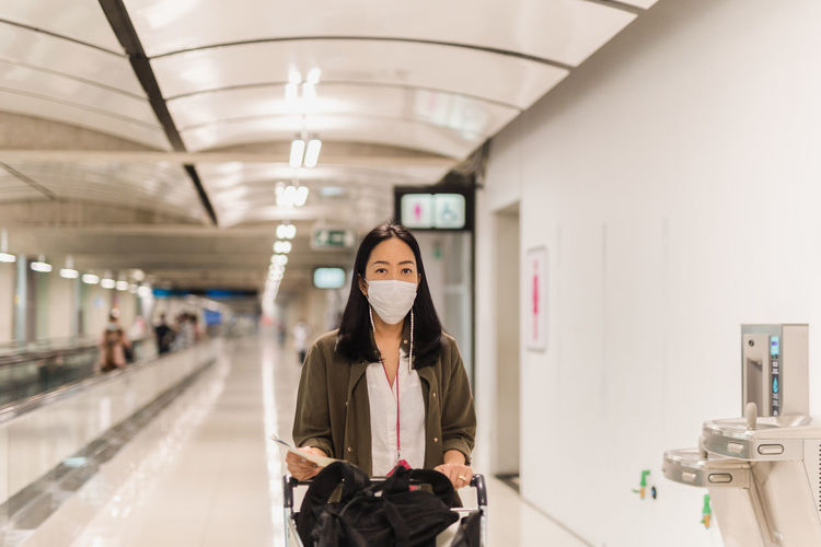Coronavirus asian woman with surgical mask walking in the airport
