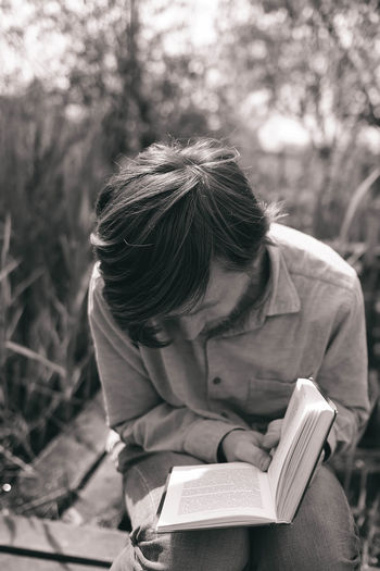 Man reading novel in park