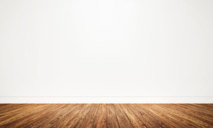 Empty wooden floor against wall