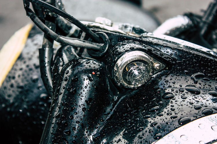 Close-up of wet motorcycle during rainy season