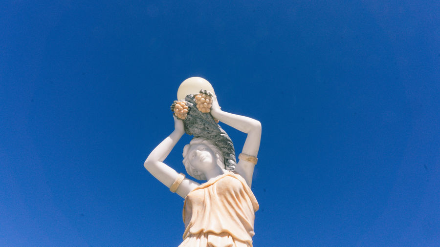 Low angle view of statue against blue sky