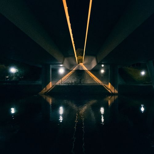 Symmetric lights under a highway by a stream