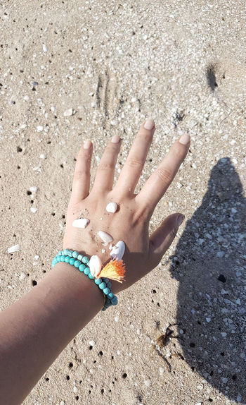 Close-up of woman hand on sand