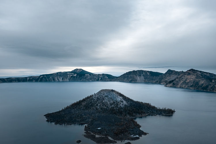 Scenic view of lake by mountains against sky