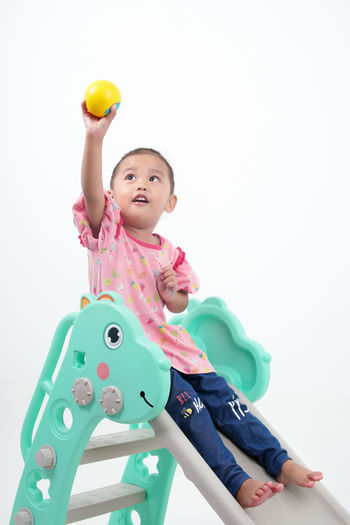 Portrait of boy playing with toys against white background