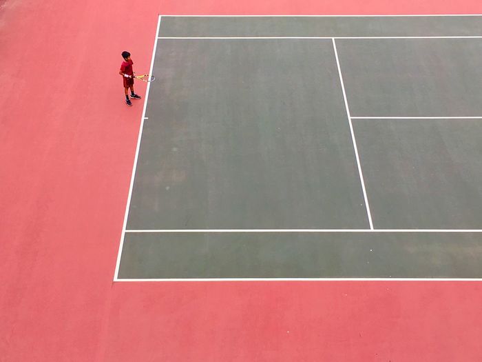 High angle view of boy playing tennis at court