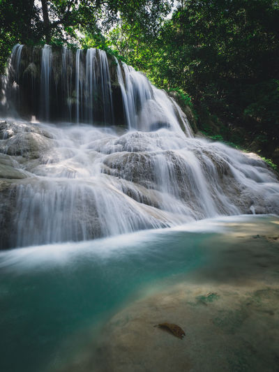Scenic paradise waterfall smooth stream in lush rainforest. erawan falls, kanchanaburi, thailand.