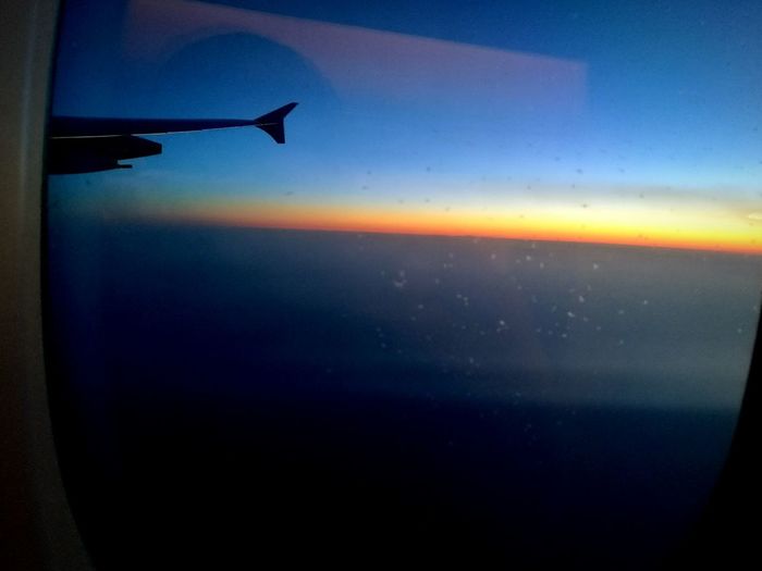 Close-up of airplane wing against sky during sunset