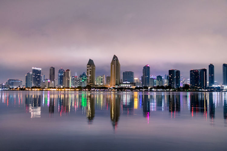 Illuminated buildings in city against sky