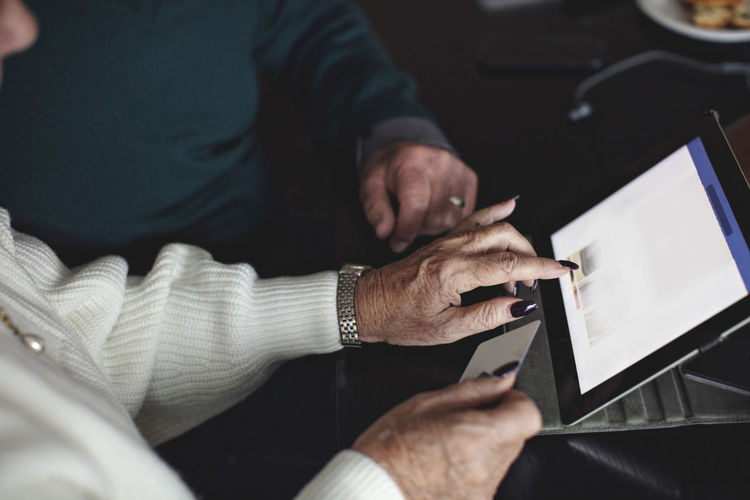 Senior couple shopping online through digital tablet at home