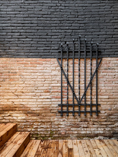 Forged steel metal decorative grille on a brick wall. preservation of vintage items