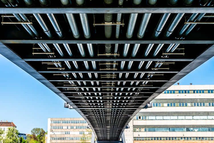 Low angle view of bridge in city against sky