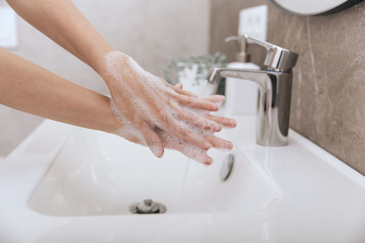 Cropped hands washing hand in sink