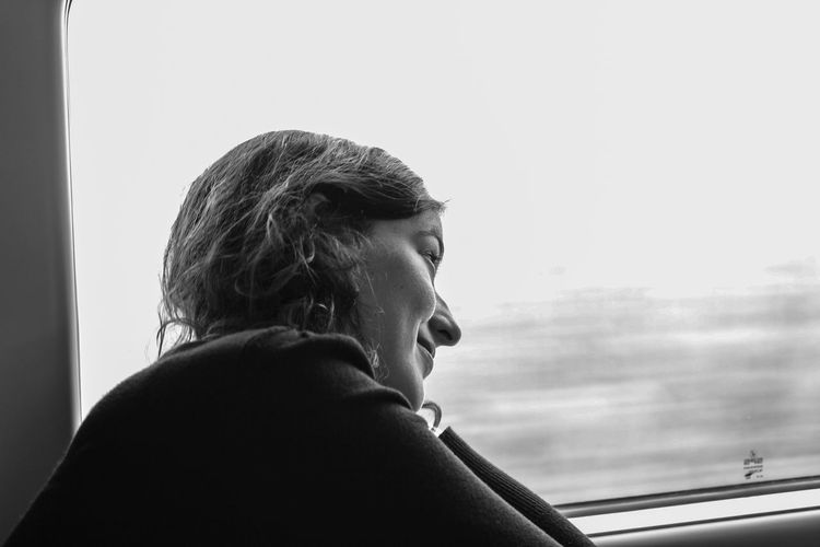 Young woman looking through train window