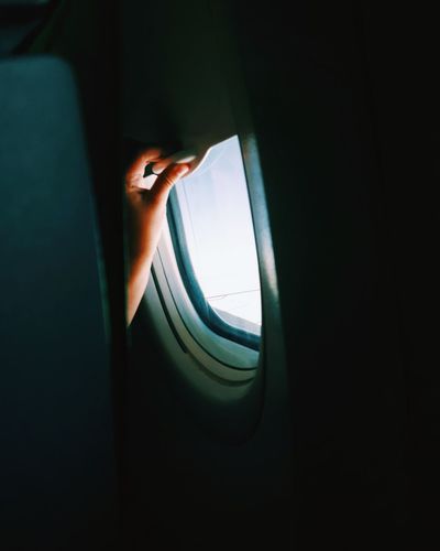 Close-up of hand on airplane window
