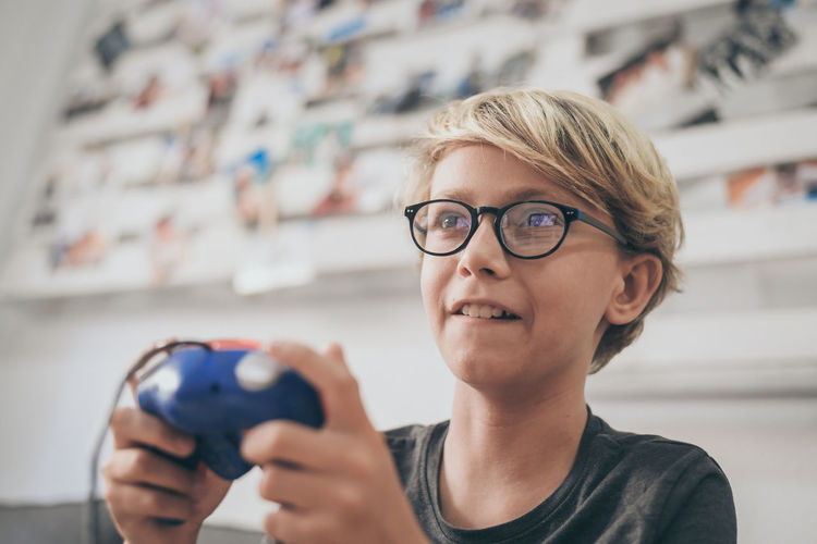 Boy playing video game in living room at home