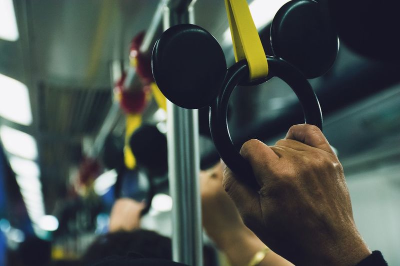 Cropped hand holding handle in train