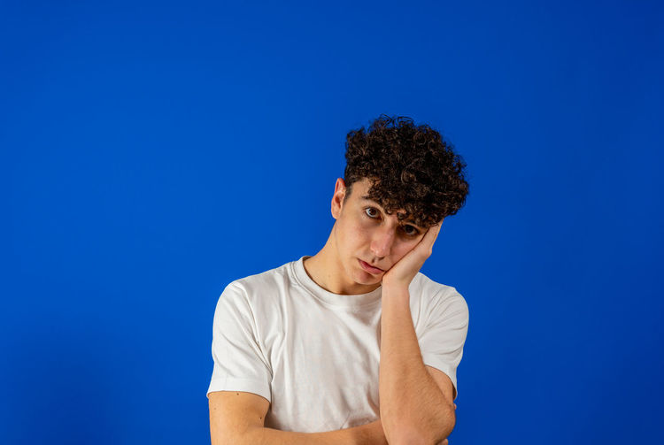 Portrait of teenage boy against blue background