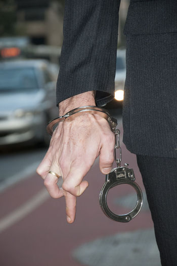 Midsection of man with handcuffs standing on street