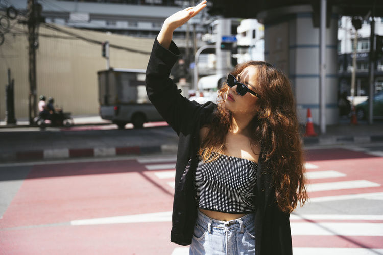 Young woman wearing sunglasses standing in city