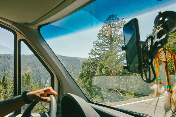 Young man driving on highway through yosemite national park.