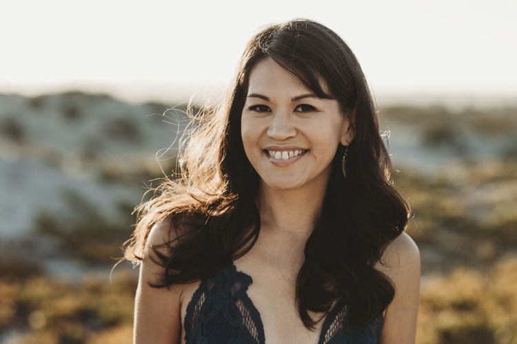Beautiful smiling mid-40's woman with long dark hair in black lace top