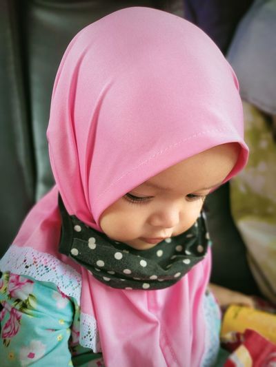 Close-up of girl wearing hijab sitting at home