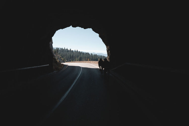 Cyclist ride through tunnel in forest