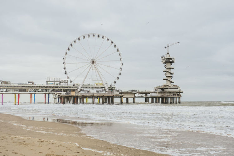 Ferris wheel on beach against sky